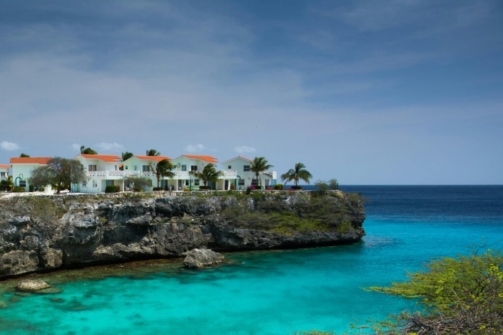 Oceanfront houses on a scenic cliff overlooking turquoise waters and blue sky.
